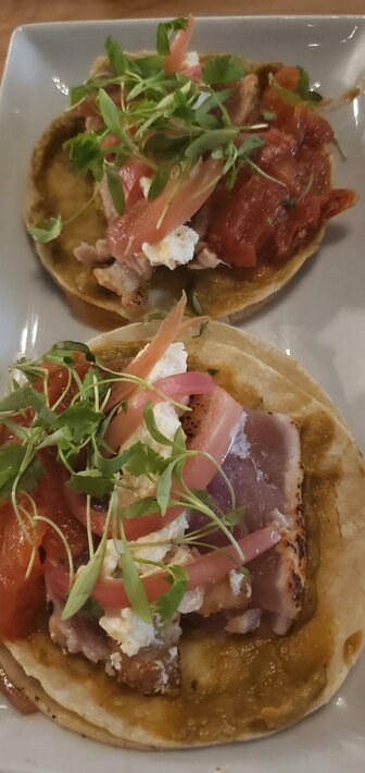 Yellowfin tuna tacos — Togarashi tuna, guajillo tortilla, red chili, avocado, pickled onion, roasted salsa, micro cilantro, goat cheese